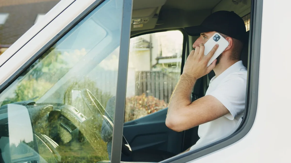 Tradesperson on a phone call while reviewing job details