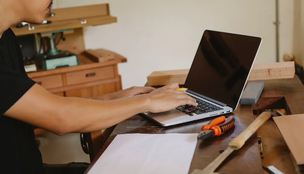 Tradesperson working on a laptop in a workshop