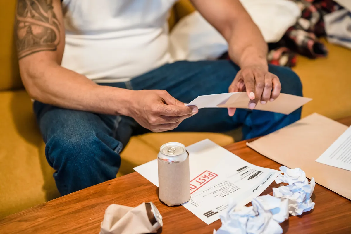 Man sorting through letters and envelopes at home