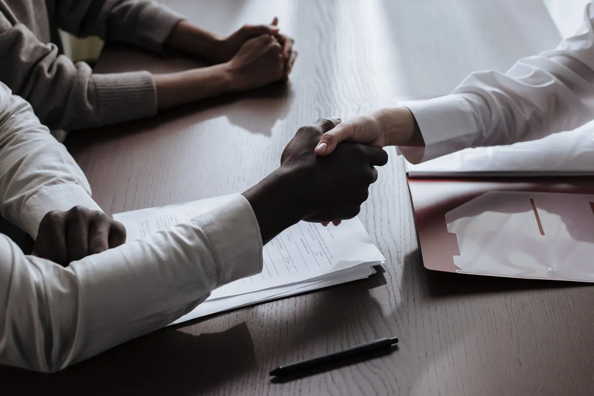 Business owner shaking hands over a signed website contract